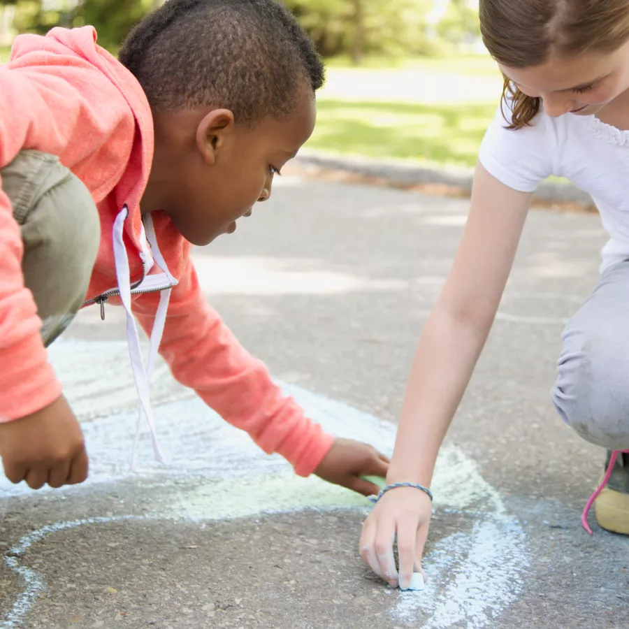 Children drawing on ground with chalk