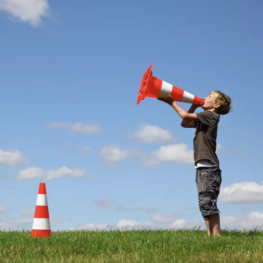 Image of child yelling into a traffic cone