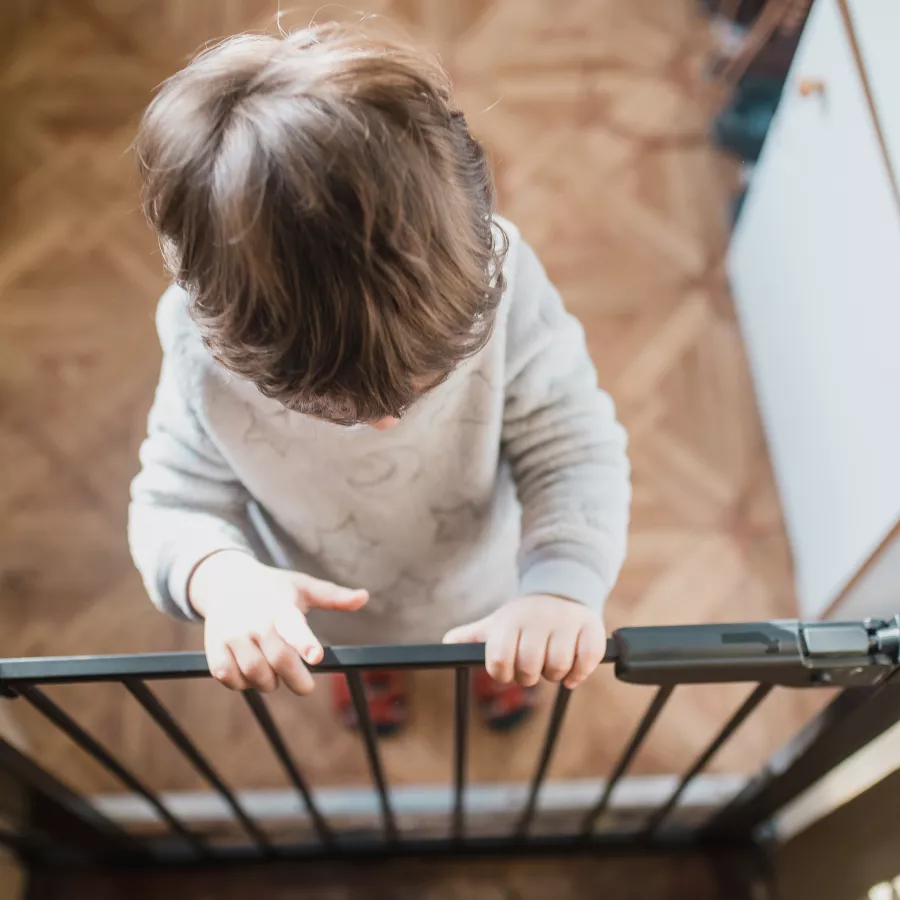 Child standing at a stair gate